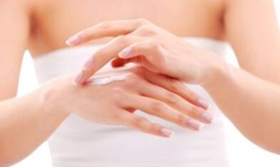 niña aplicándose ungüento en la mano